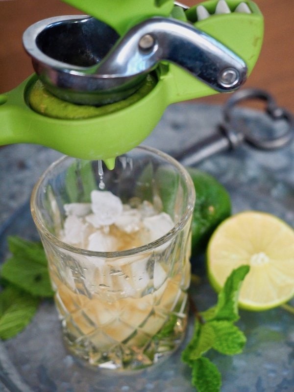 squeezing lime into cocktail glass for mule | www.thefreshcooky.com