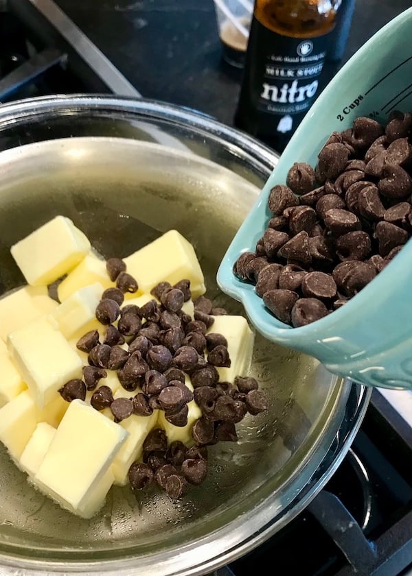 Pouring chocolate chips over butter in double boiler | www.thefreshcooky.com