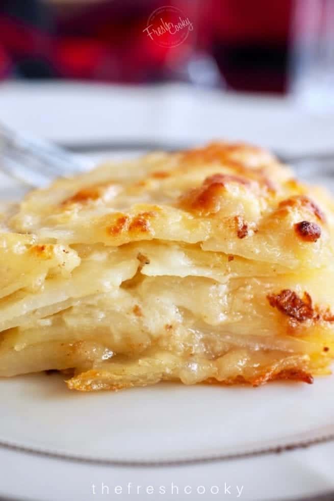 square of baked potato au gratin on a pretty china dish