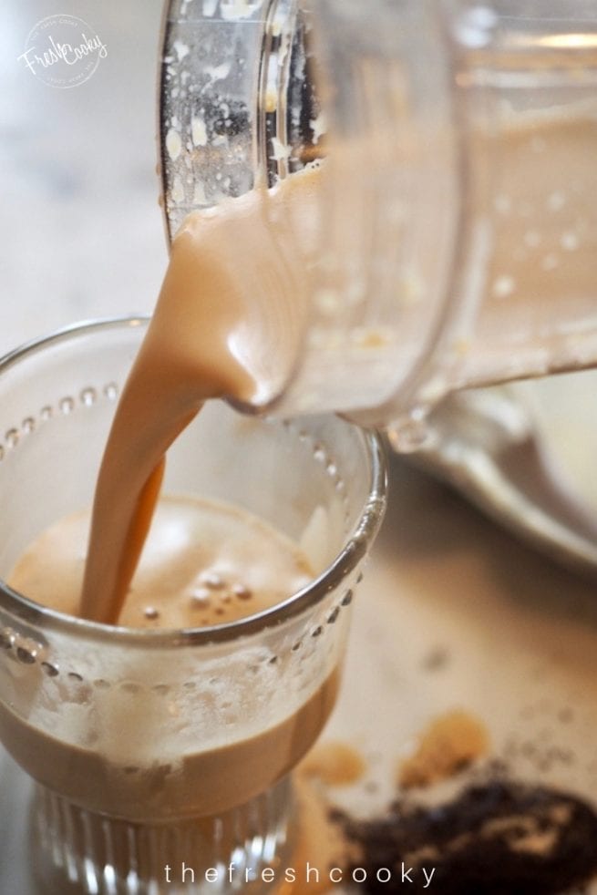 Pouring in Bulletproof Coffee into glass after blending | www.thefreshcooky.com