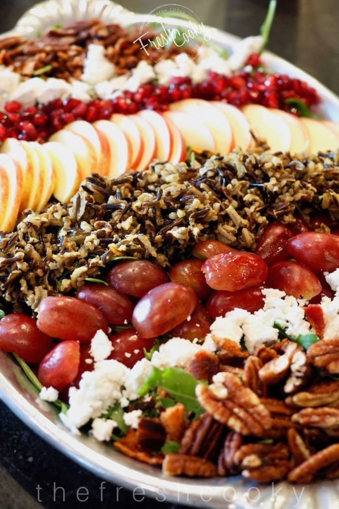 Wild rice harvest salad on a platter with grapes, pecans, goat cheese and pomegranate.