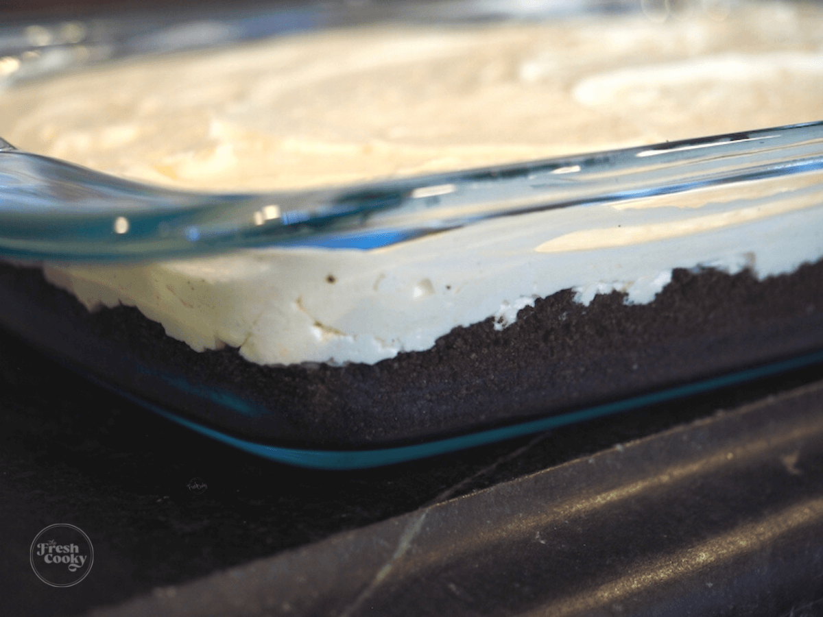 Pudding and cream cheese mixture on top of Oreo cookie crust for Easter Dirt Cake.