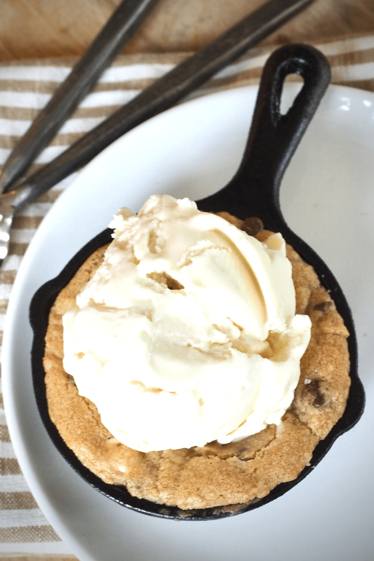 Mini Skillet chocolate chip cookie with vanilla ice cream scoop on top.
