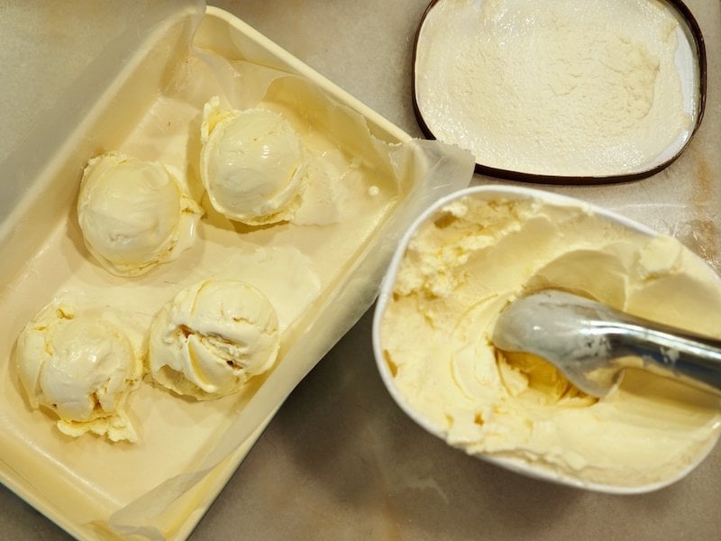 Scooping vanilla ice cream into lined pan and prefreezing for easier serving for half baked cookies.