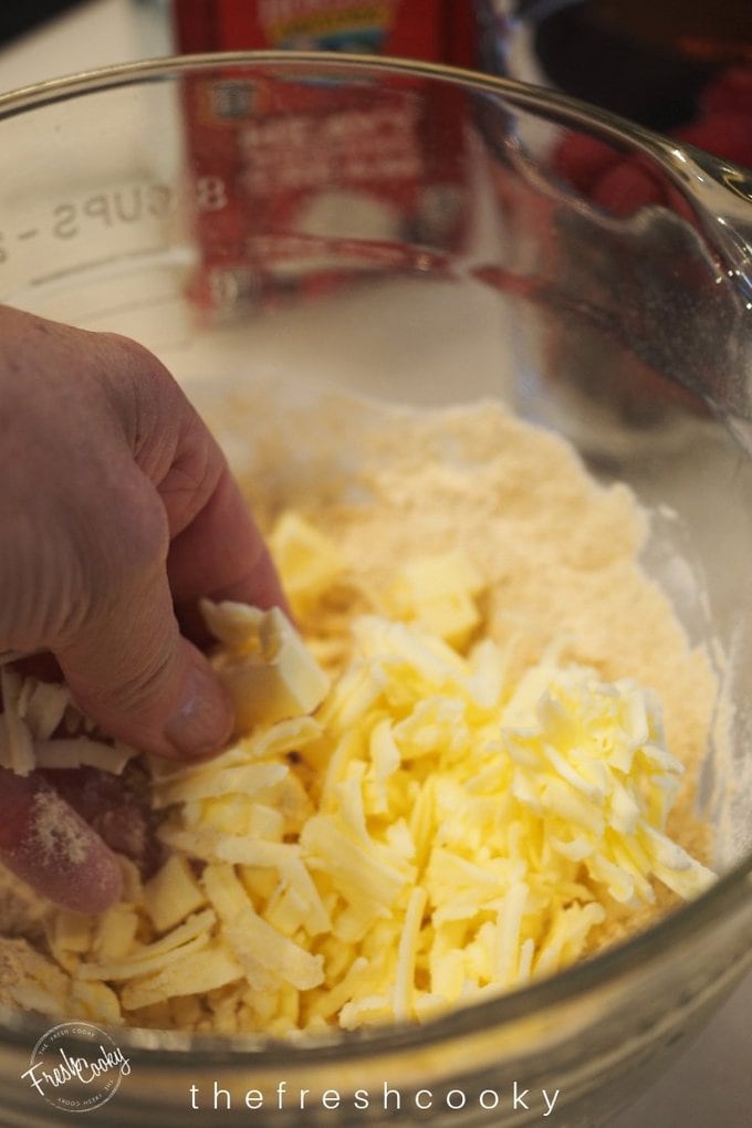 Hand cutting in shredded butter for raspberry scones.