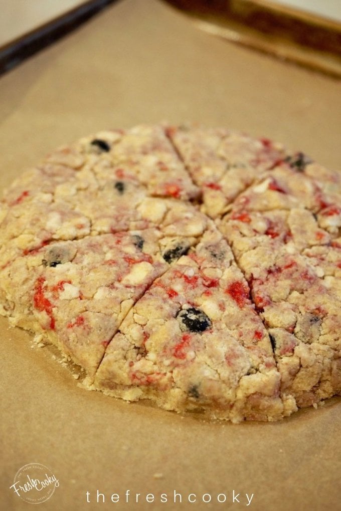 scone disc with fresh blueberries, raspberries in the batter, cut into wedges.