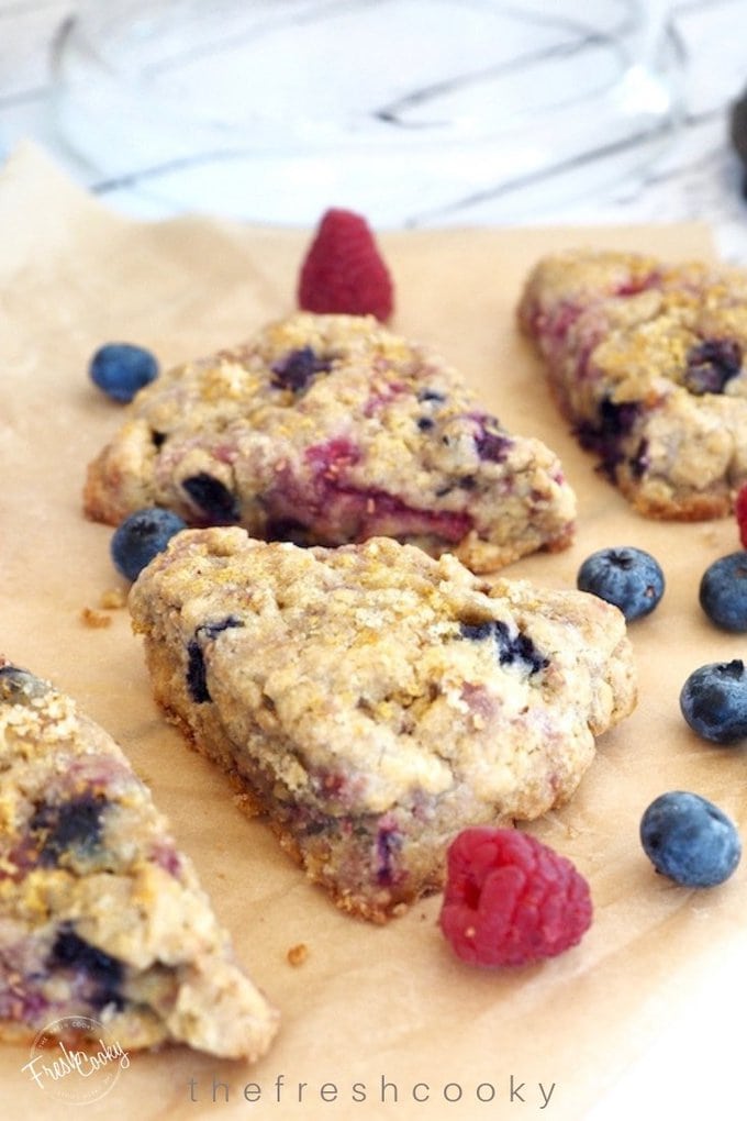 Glazed Raspberry Blueberry Scones with simple sugar topping on parchment. 
