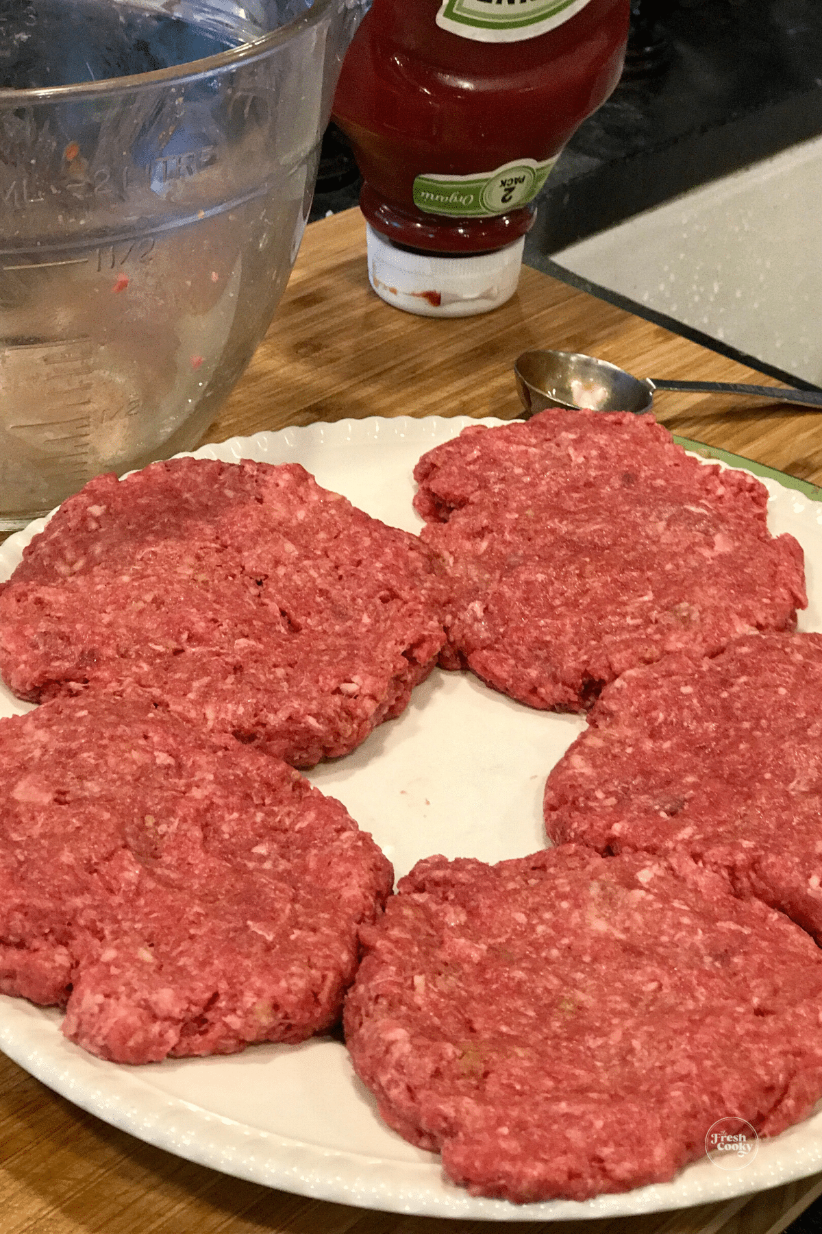Bison meat pressed into patties on plate. 