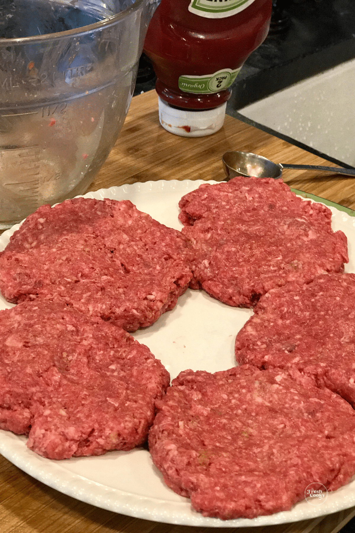 Bison meat pressed into patties on plate.