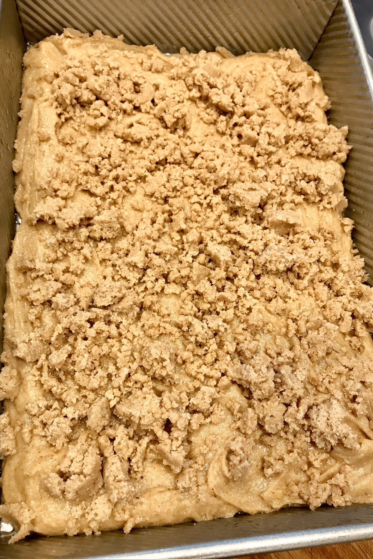 Cinnamon crumb streusel crumbled on top of the gluten-free coffee cake batter. 