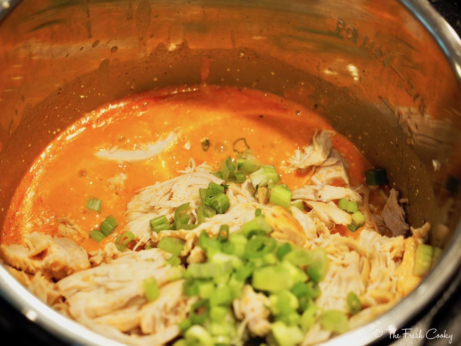 Tossing shredded chicken back in sauce with green onions and celery | thefreshcooky.com