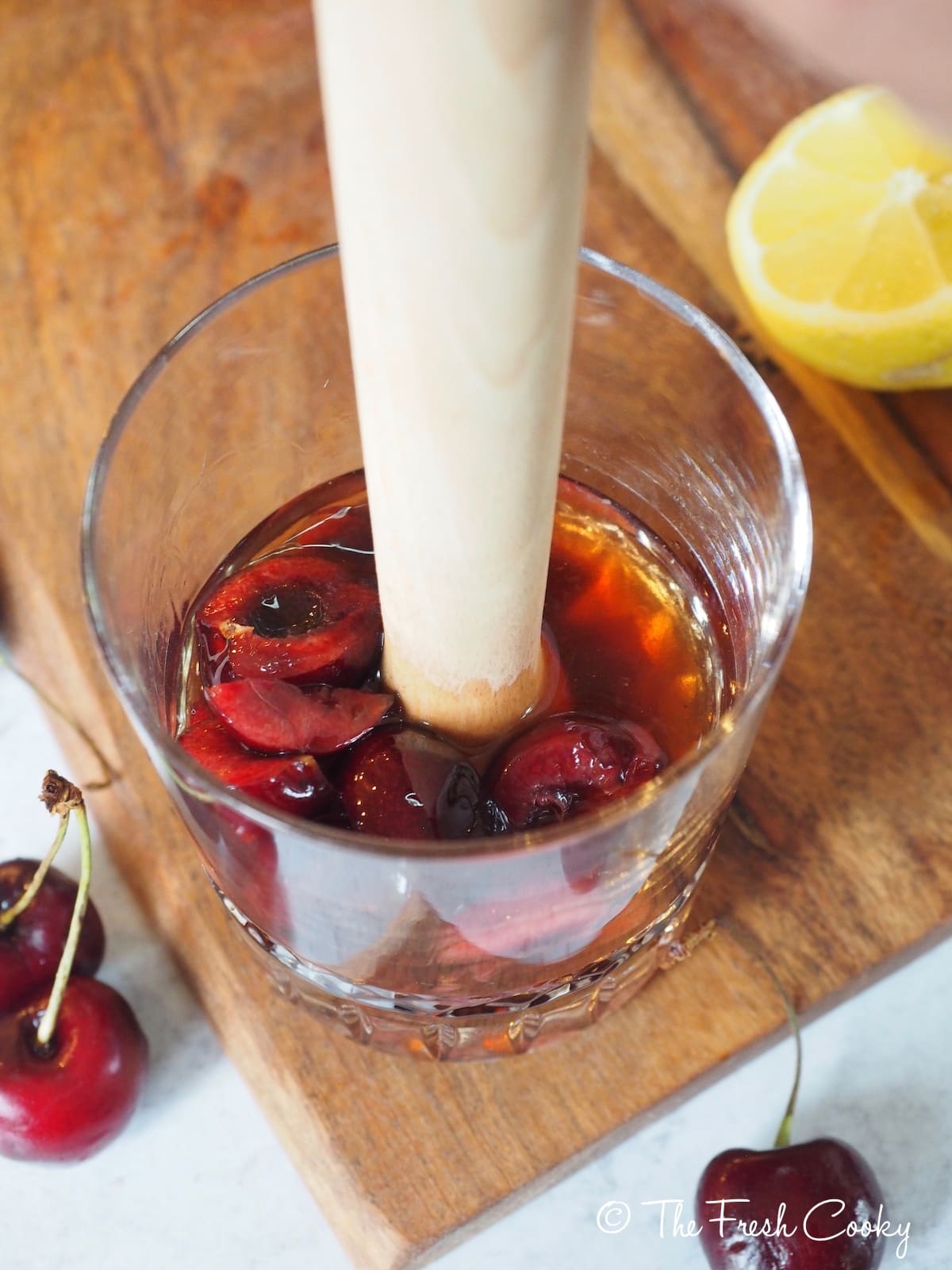 Using a muddler to press the juice out of the fresh cherries for Cherry Bomb Cocktail. 