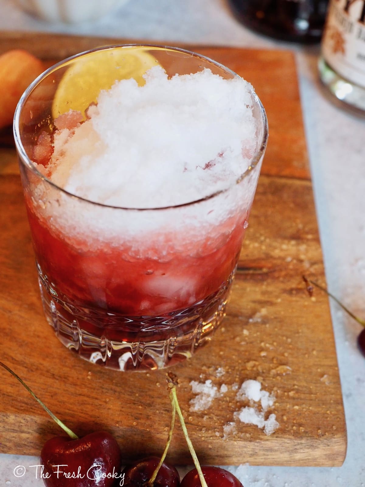 Cocktail glass filled with crushed ice for Cherry Bomb Cocktail.