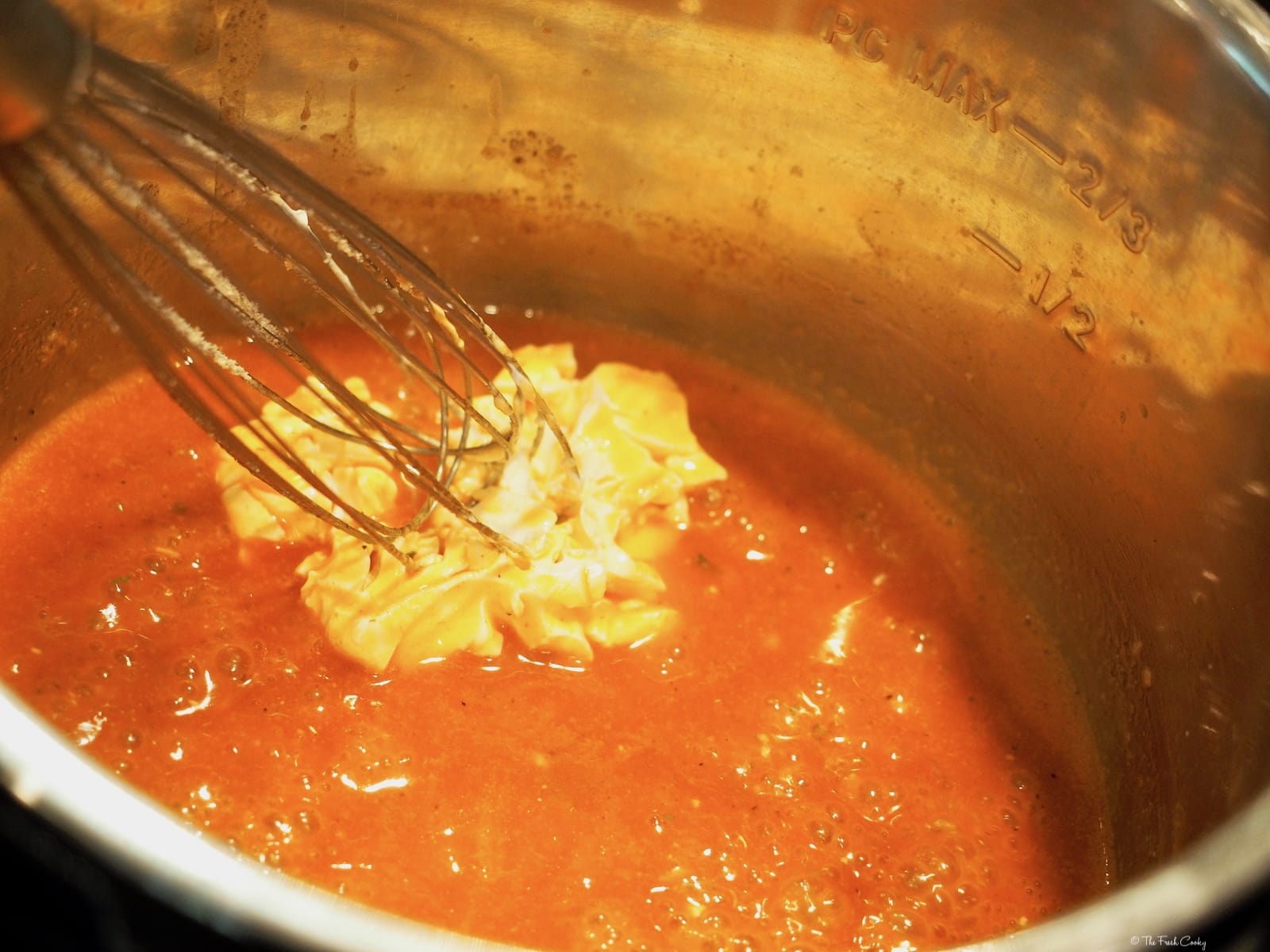 whisking in cream cheese into buffalo chicken sauce | thefreshcooky.com