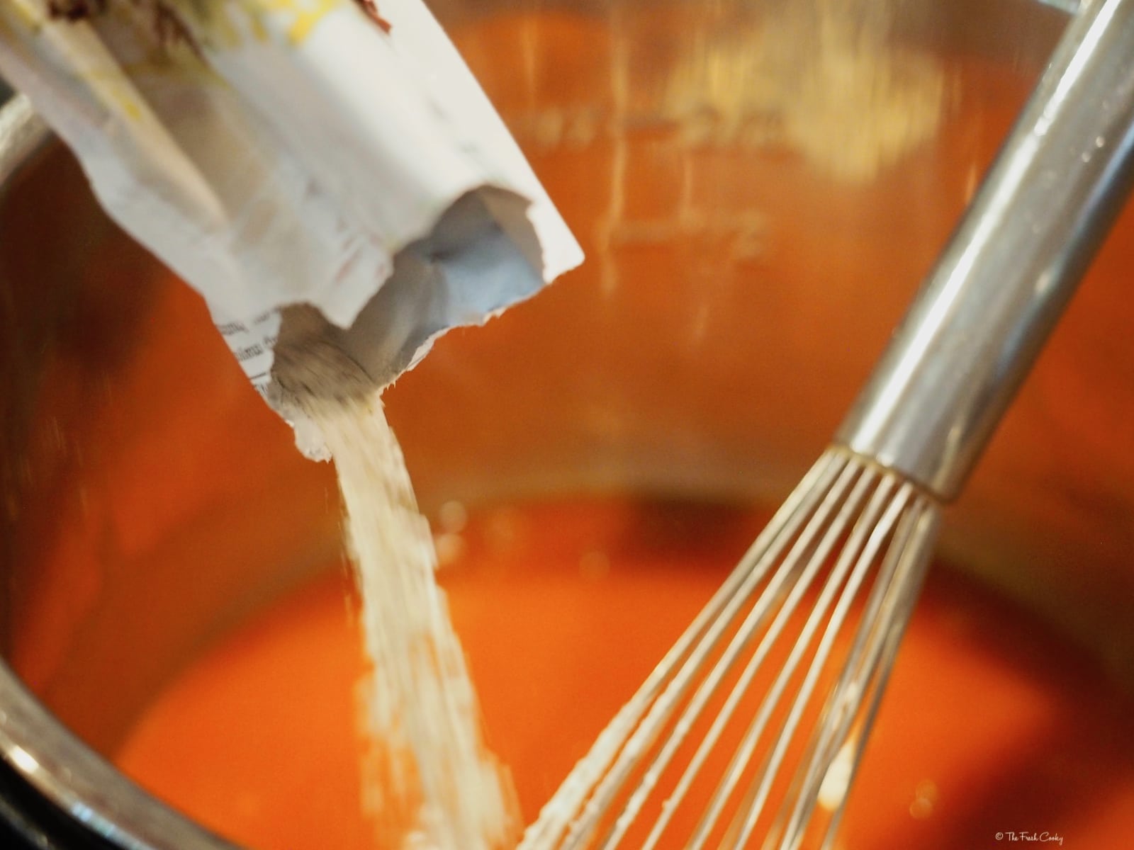 pouring ranch dressing into sauce with whisk for buffalo sauce | thefreshcooky.com 