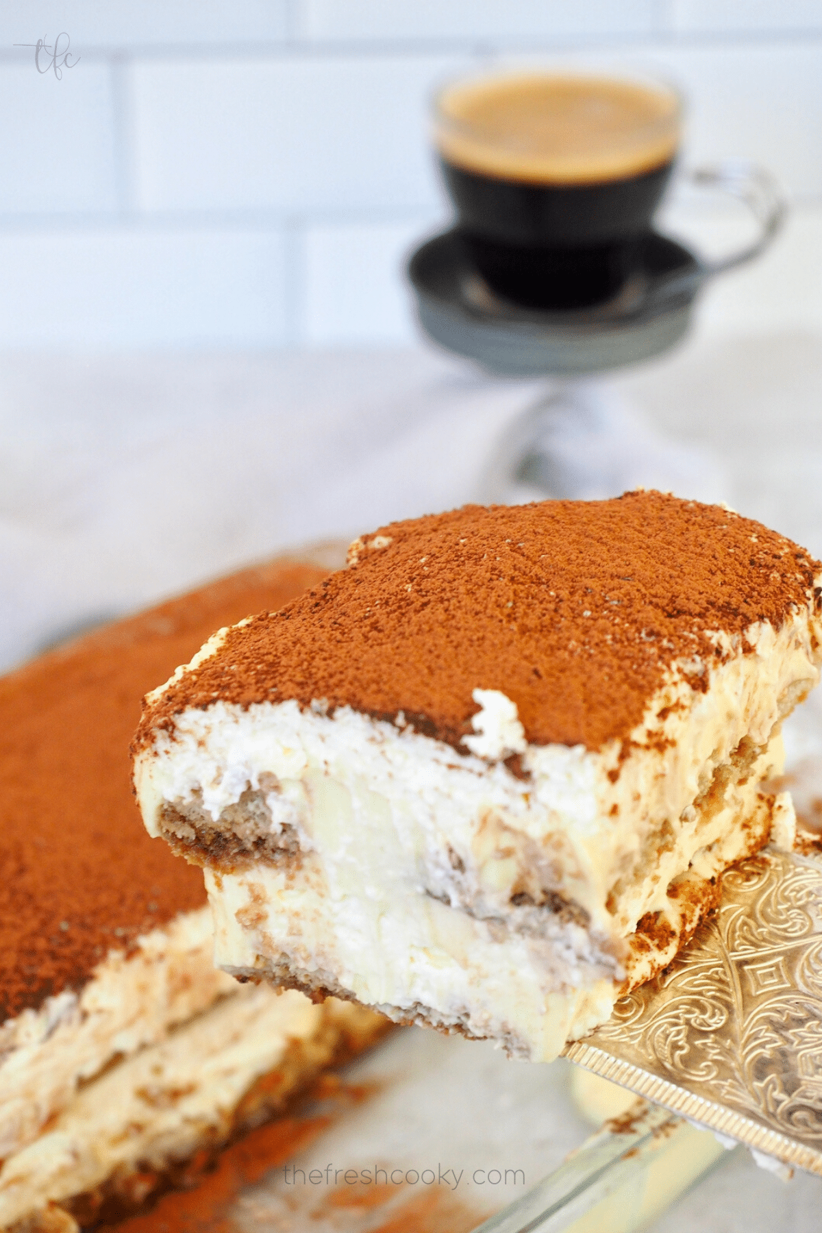 Lifting out a slice of layered Italian traditional tiramisu dessert.