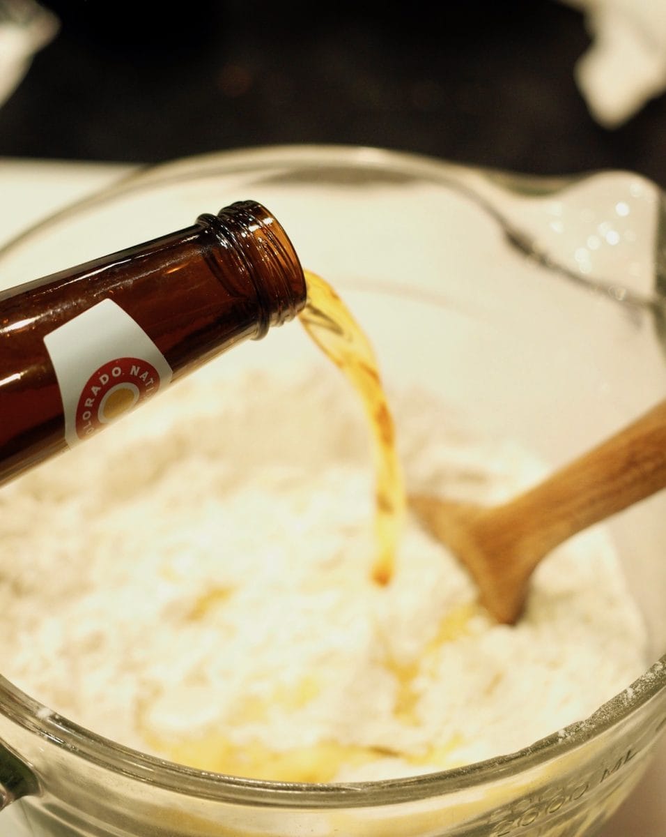 pouring beer in dry ingredients for cheddar beer popovers | thefreshcooky.com