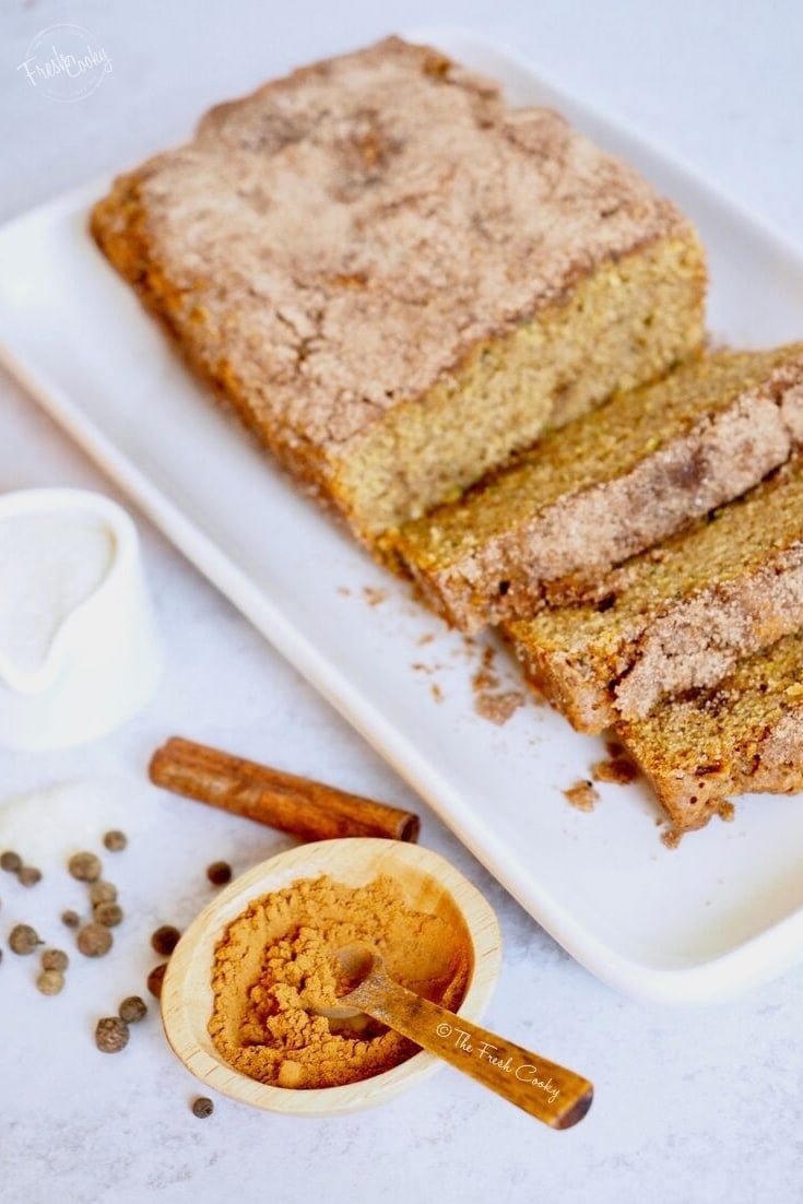Healthier Zucchini Bread sliced on a platter with cinnamon and sugar.