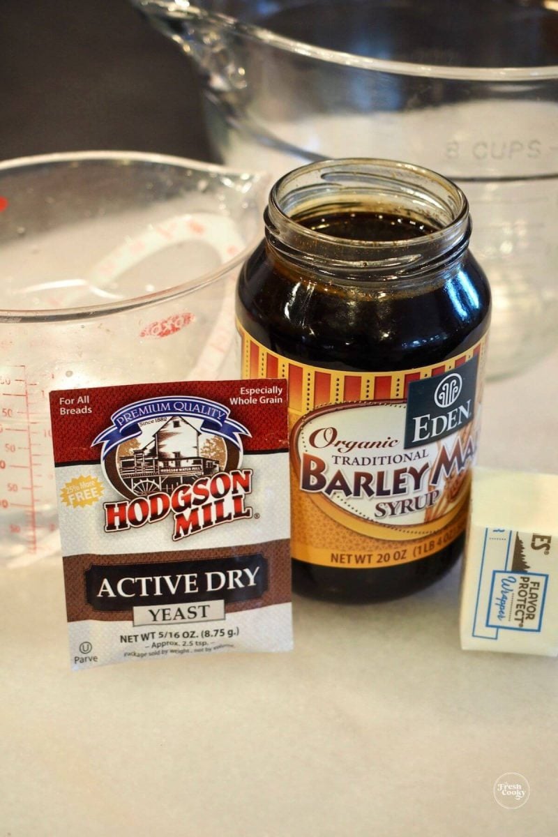 Jar of barley malt syrup and package of yeast with butter ingredients for brezels. 
