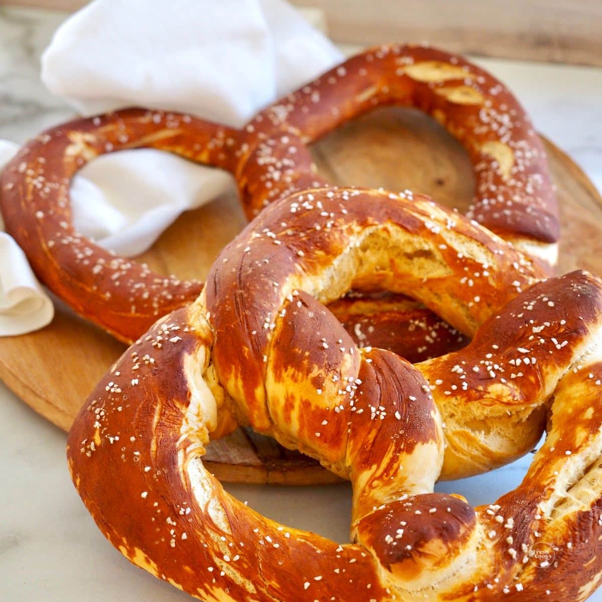 Bavarian pretzels, giant-sized on a cutting board. 