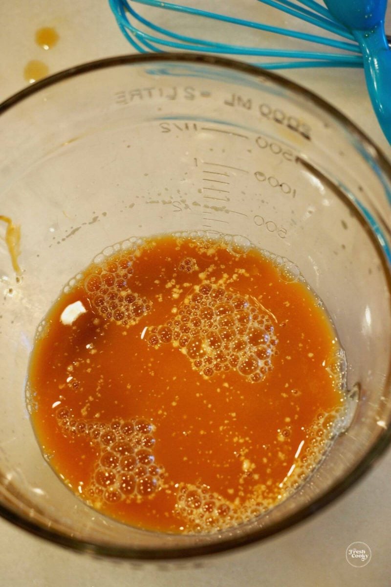 Yeast, water and barley malt syrup mixed in small bowl. 