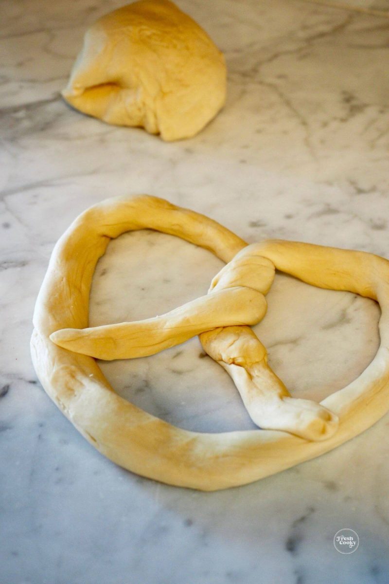 Shaped Bavarian pretzel on marble counter.