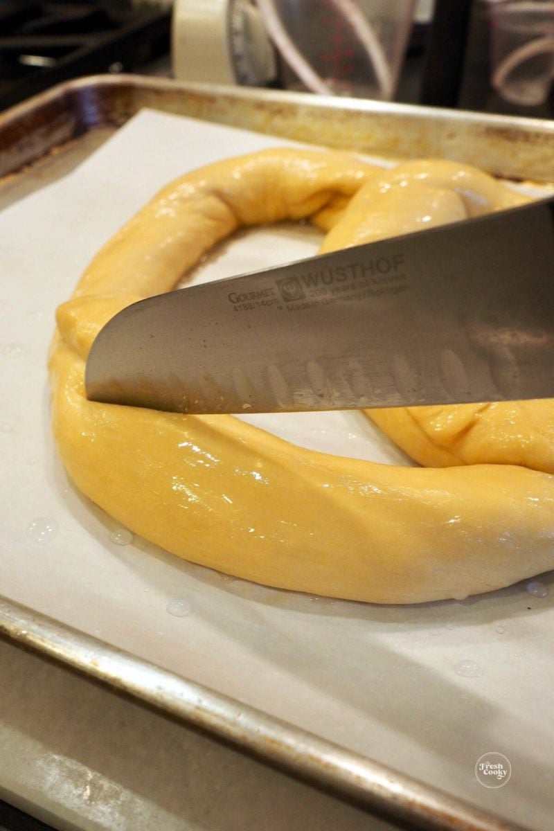 Slash the lower portion of the pretzel with a sharp knife.