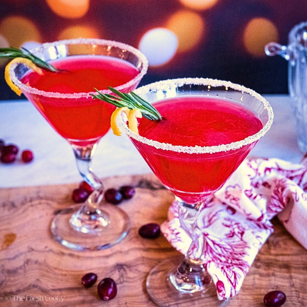 Cranberry Lemon Drop Martini in two pretty glasses rimmed with sugar, perfect Christmas cocktail.