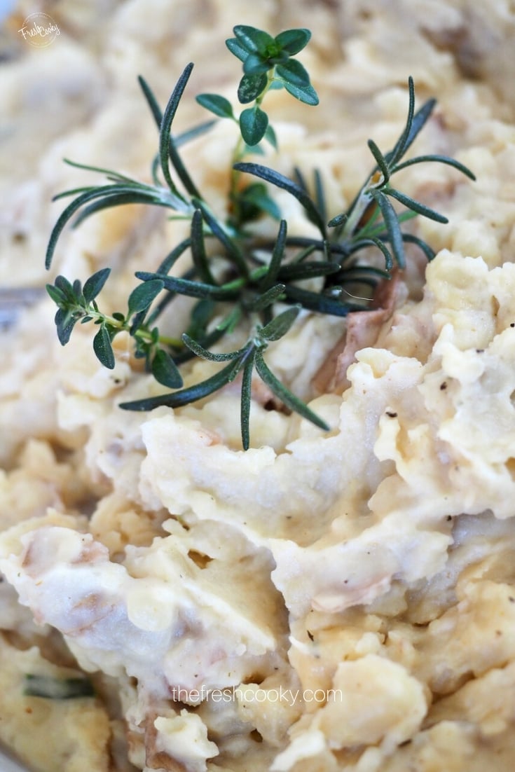 Creamy mashed potatoes with boursin cheese and garnished with fresh thyme and rosemary. 