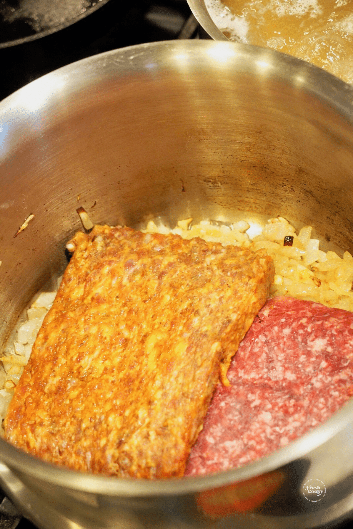Browning sausage and ground beef in onions in pot. 