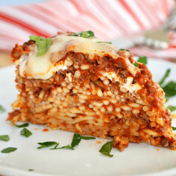 Baked Spaghetti Pie slice on a plate showing the layers of delicious cheese and meat sauce.