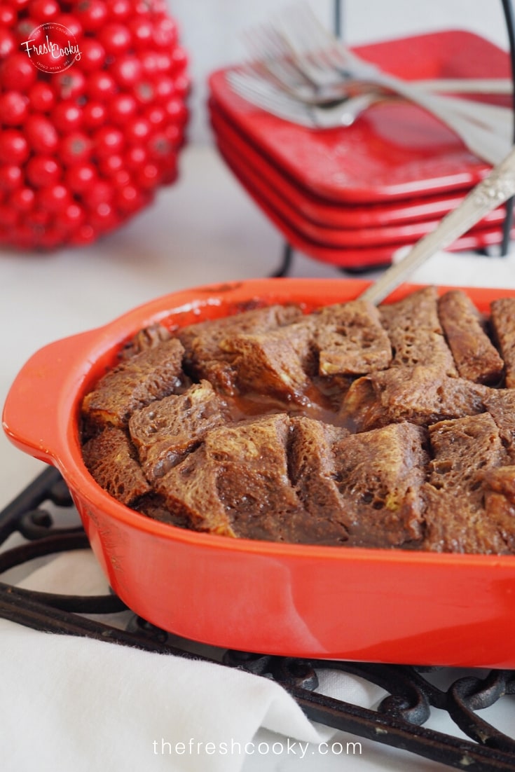 Pretty red casserole filled with chocolate bread pudding. 