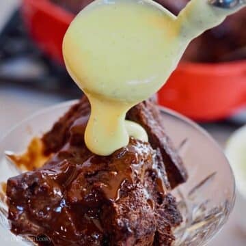 Pouring creme anglaise over chocolate bread pudding.