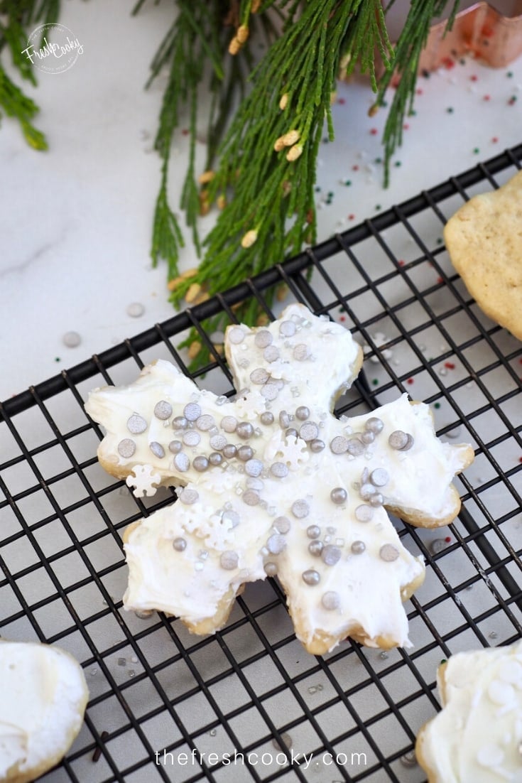 Snowflake cut out cookie, frosted and covered in silver sprinkles. 