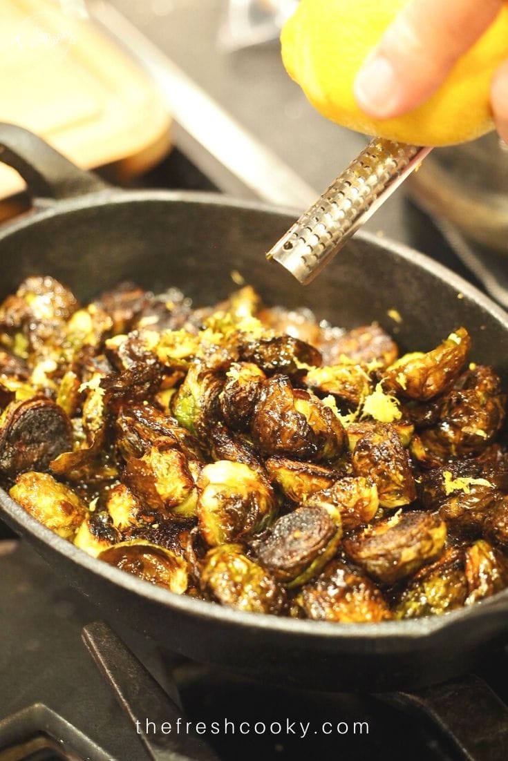Zesting Lemon onto hot cast iron pan of brussels sprouts.