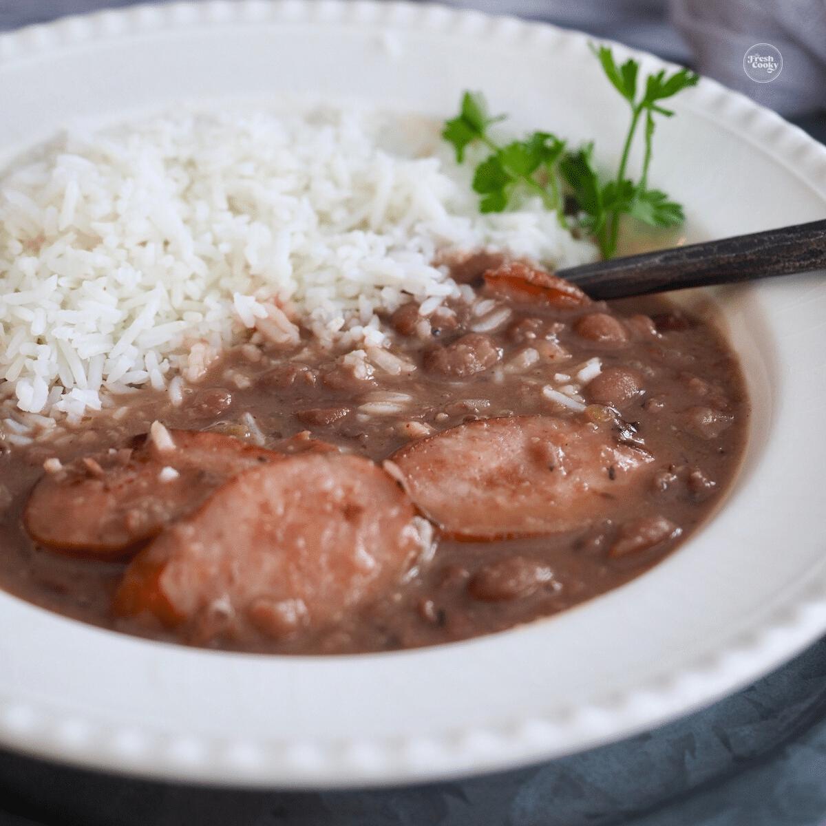 Red beans and rice in bowl with sausage, ham and chicken.