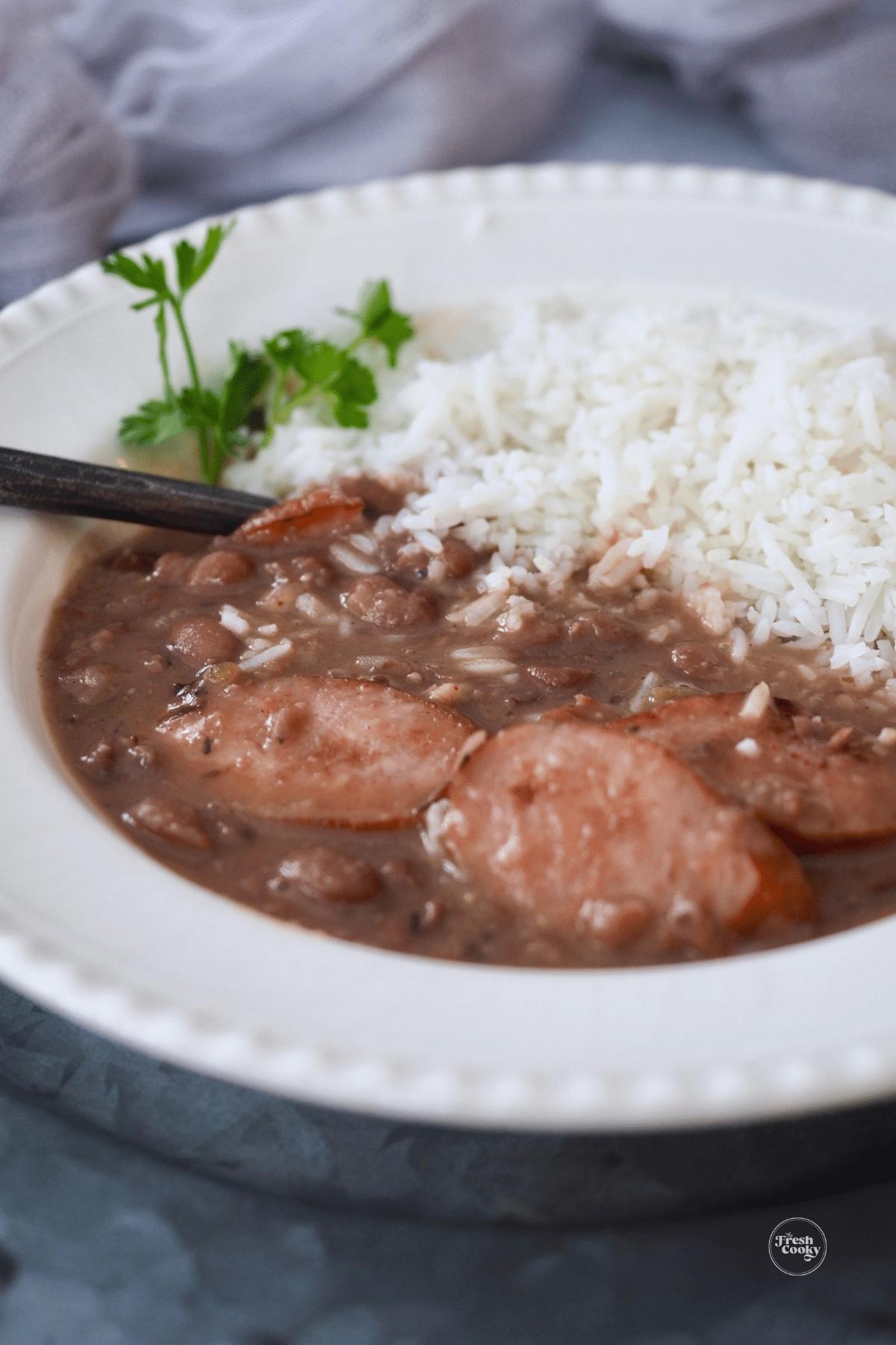 Red beans and rice in a bowl with a serving spoon.