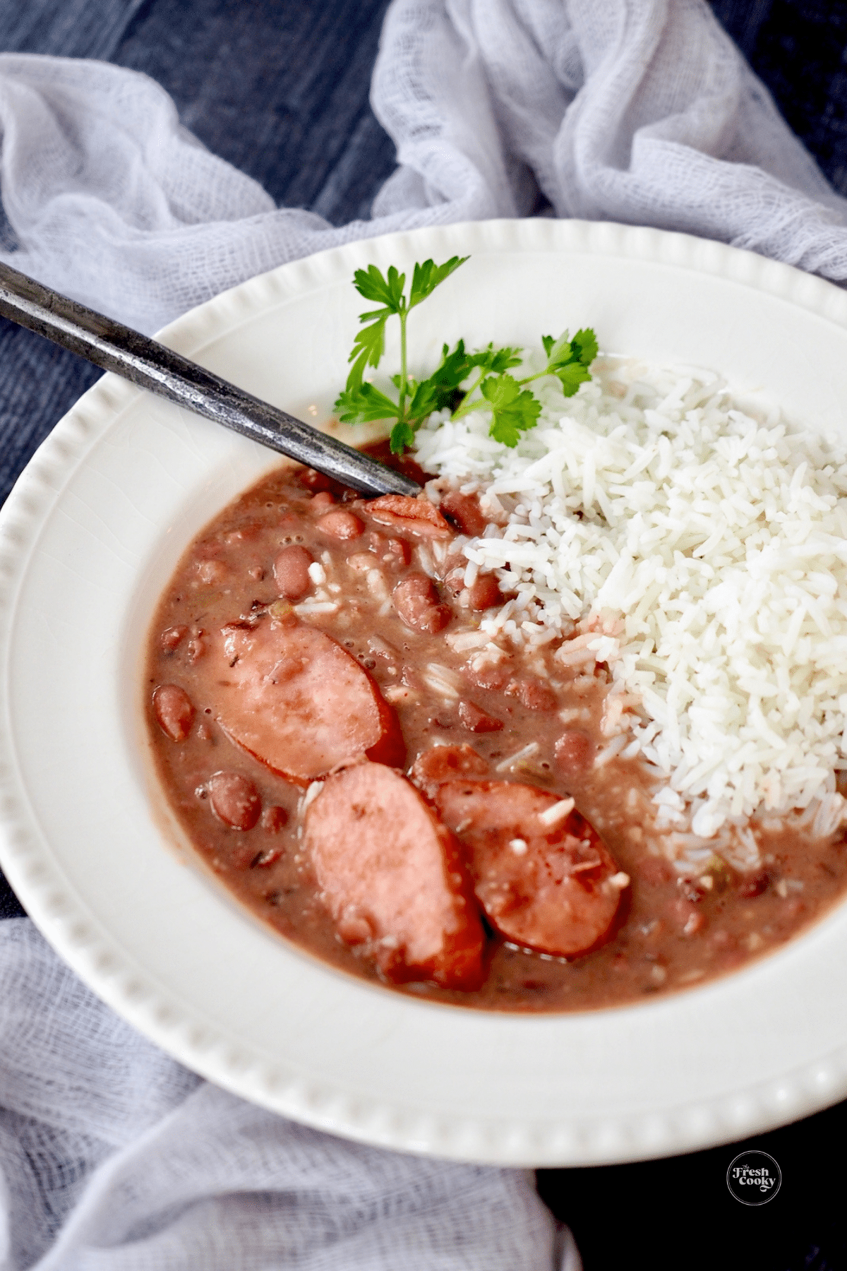 A large bowl filled with tender red beans and rice and sausage.