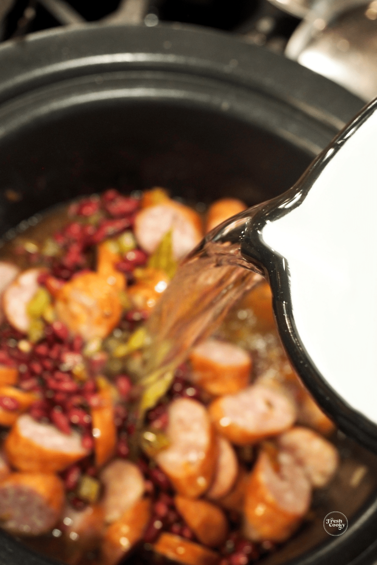 Pouring water into slow cooker for red beans and rice.