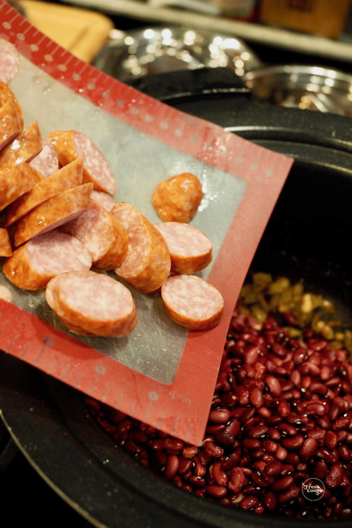 Adding sausage to crockpot for red beans and rice.