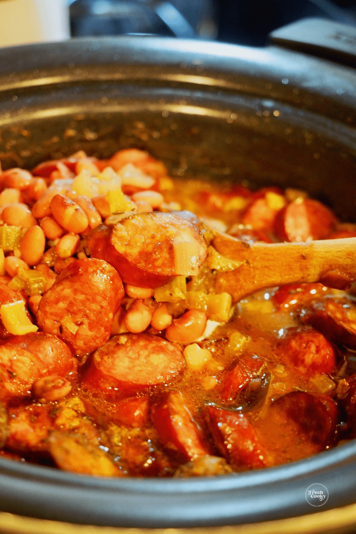 Stirring cooked red beans and rice in slow cooker.