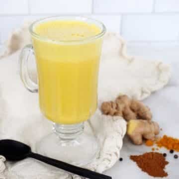Pretty mug of bright yellow golden milk tea.