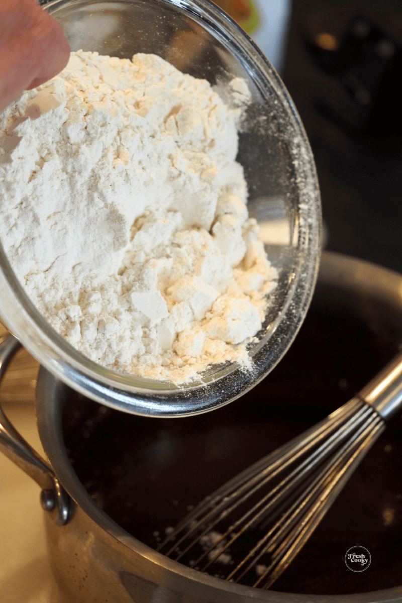 Adding flour to guinness cake batter mixture.
