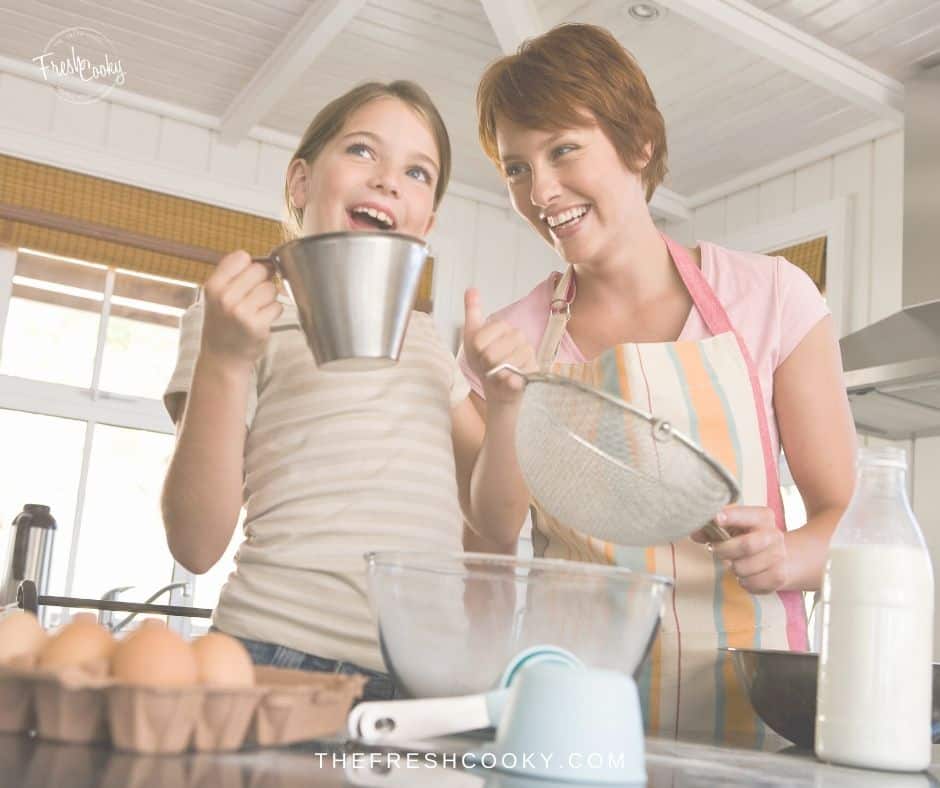 Mom and daughter baking together with big smiles. 