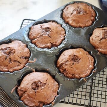 Baked mini bundt cakes in pan on cooling rack.