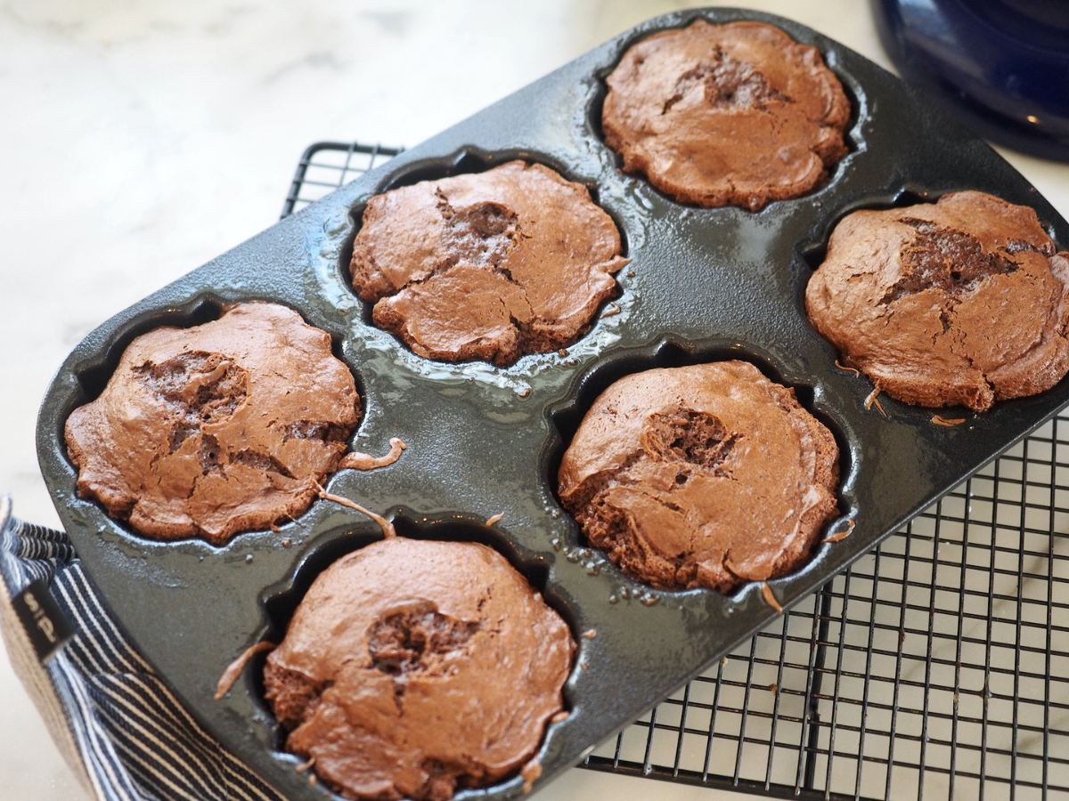 Baked mini bundt cakes in pan on cooling rack.
