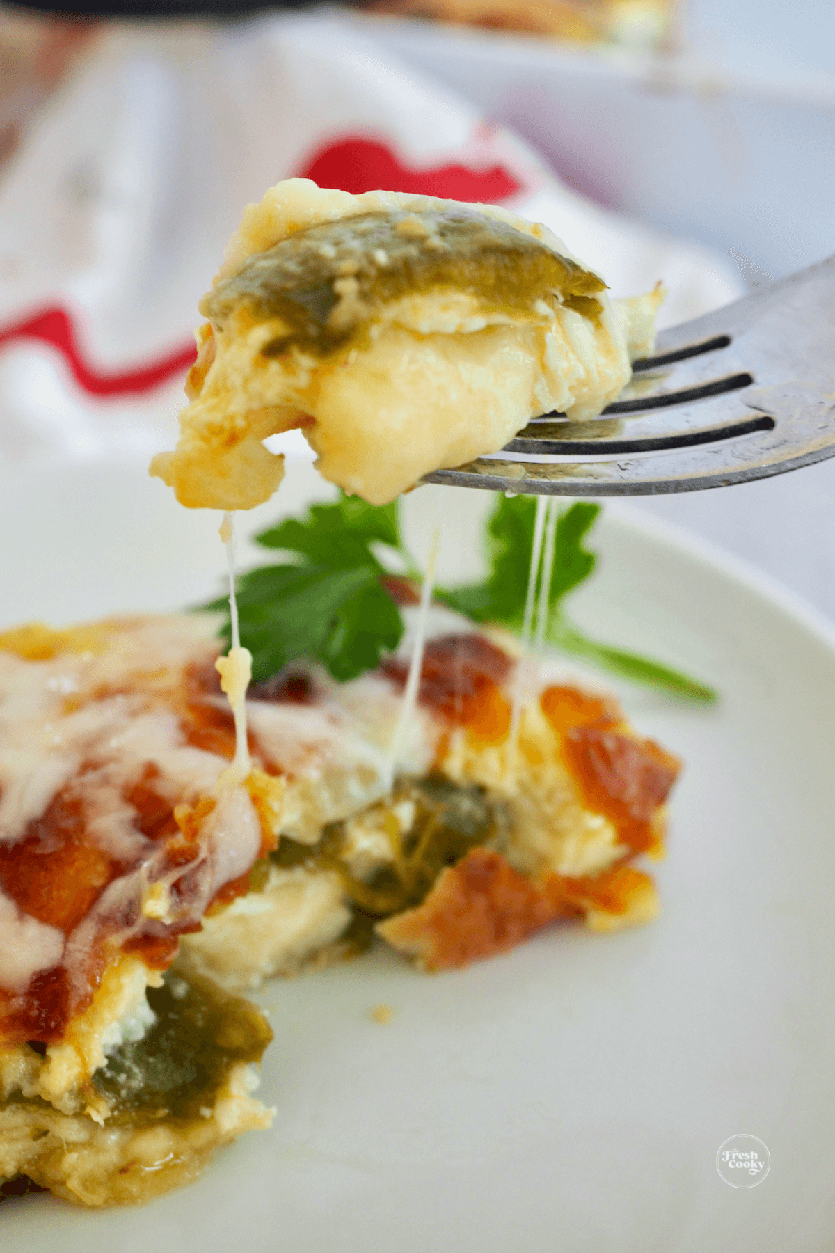 Chile relleno casserole with forkful of gooey cheesy chile.