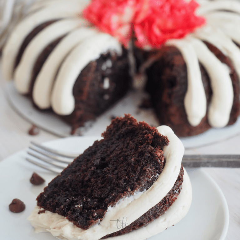 Nothing Bundt Cakes recipe with slice of chocolate chocolate chip nothing bundt cakes on plate with full cake in background.