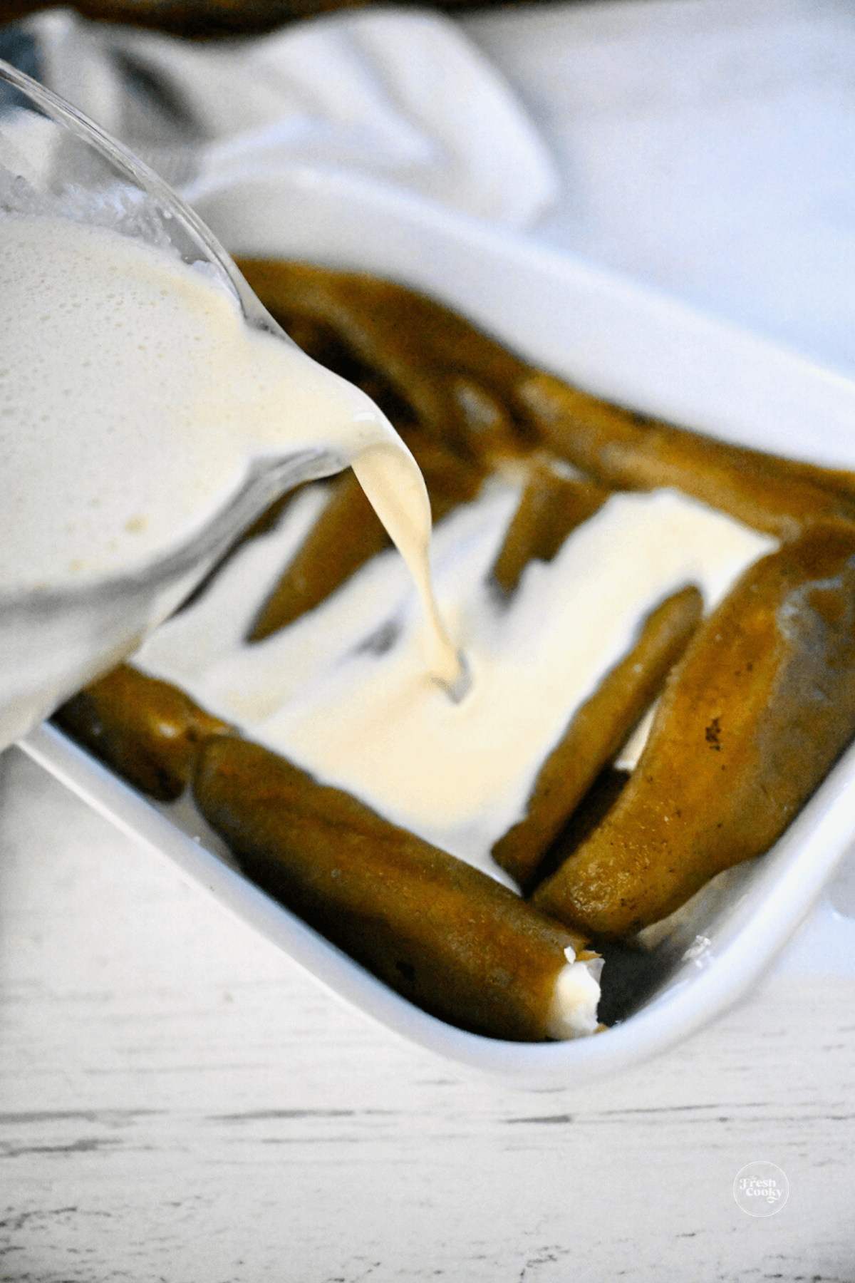 Pouring egg batter over chiles.