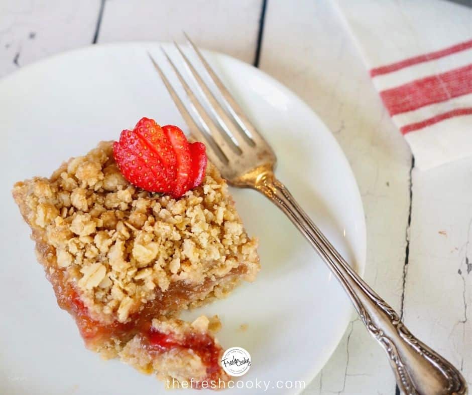 facebook image for gluten free strawberry rhubarb crisp with square on plate with antique silver fork.